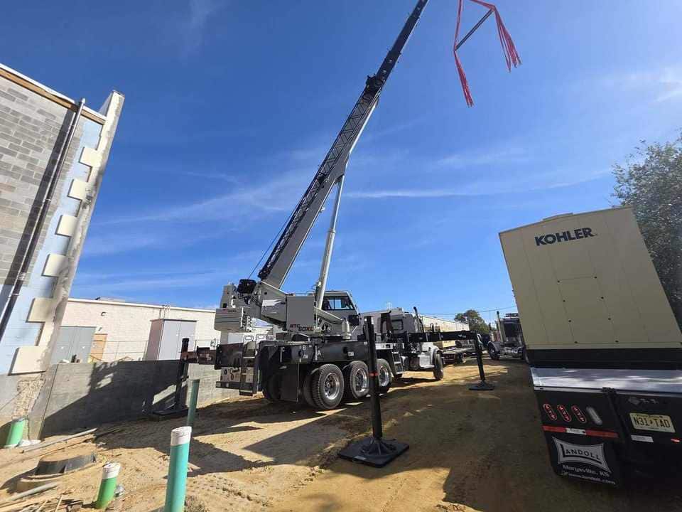 Steedle truck crane beside a Kohler standby generator on a construction jobsite
