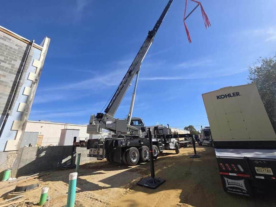 Steedle truck crane beside a Kohler standby generator on a construction jobsite